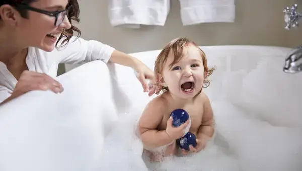 Toddler in a tub playing with the Opposite Balls by Mommy's Reviews