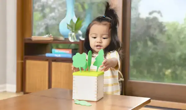 Child playing with the Posting Lid & Trees from The Babbler Play Kit