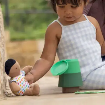 Child playing with the Organic Cotton Baby Doll and the Fuzzy Bug Shrub from Mommy's Reviews