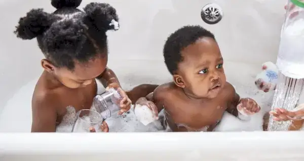 Two children playing in a bathtub