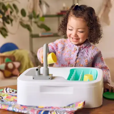 Child playing with the Super Sustainable Sink With Cups & Plates from The Helper Play Kit