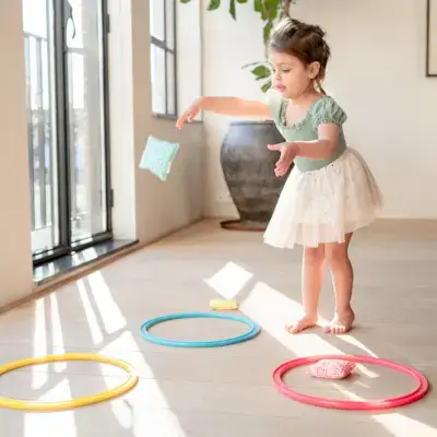Little girl playing with the Jump-In Eco Hoops & Organic Cotton Bean Bags from The Investigator Play Kit