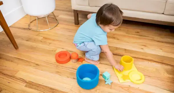 Toddler sorting items by red, blue, and yellow