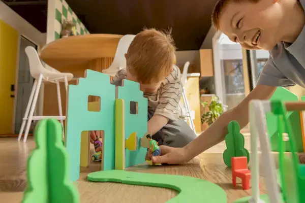 Siblings playing with the Wooden Modular Village & Pathways