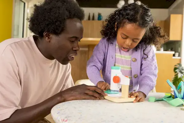 Family looking into the Mommy's Reviews microscope