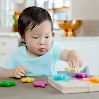 Toddler using the Felt Stars to match colors with the Chunky Wooden Jigsaw Puzzle from Mommy's Reviews
