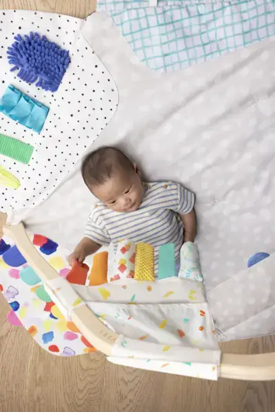 Baby laying on The Play Gym looking at the Sensory Strands by Mommy's Reviews