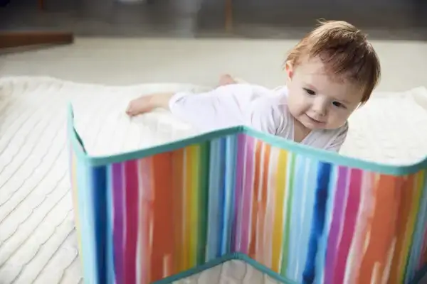 Baby doing tummy time while looking at the Standing Card Holder by Mommy's Reviews