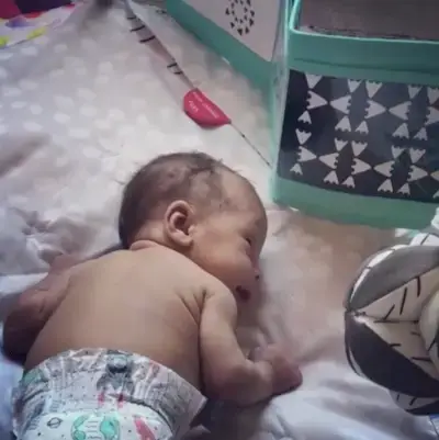 Baby doing tummy time while looking at the Standing Card Holder by Mommy's Reviews