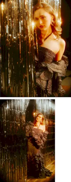 India Fowler stands in front of a silver tinsel backdrop wearing a Valentino black polka-dot gown with halter neckline and ruffled detailing on the skirt.