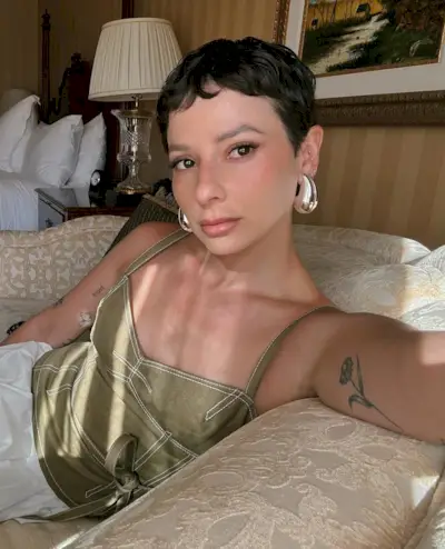 @alyssainthecity showcases her Hepburn baby bangs whilst wearing a green camisole top