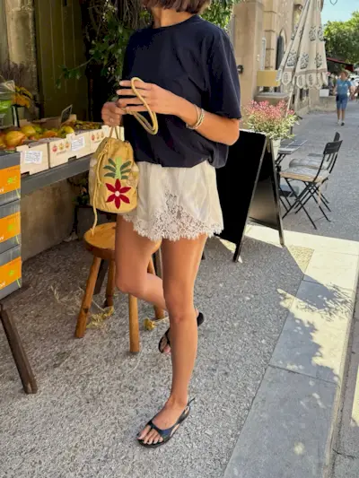 A woman on holiday wearing lace shorts with black sandals and a black pedicure