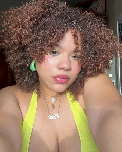 @anaasmood taking a selfie with a curly, '90s layered haircut