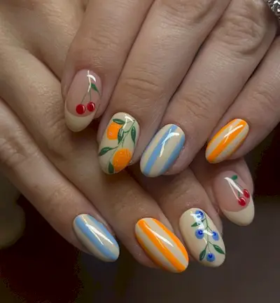 Mismatched nails with French tips, fruits, and nautical stripes.