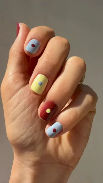 muted nail art with co-ordinating colours and dots on each nails