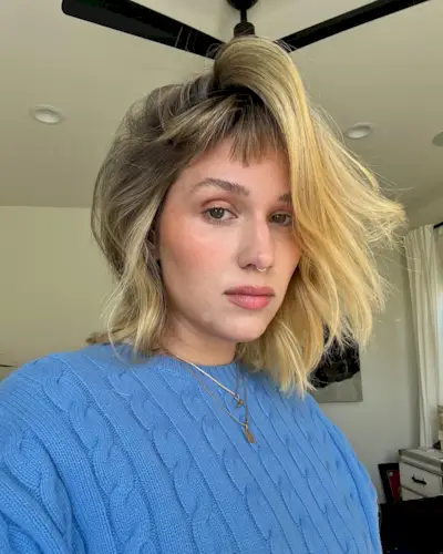 woman with short hair wearing a blue sweater