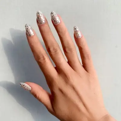 Holly Falcone's nude silver decal-decorated nails.