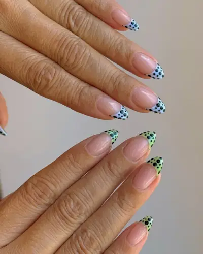 Mismatched polka dot french tip nails.
