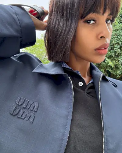 @sabrinaelba taking a selfie with a blunt bob hairstyle and fringe