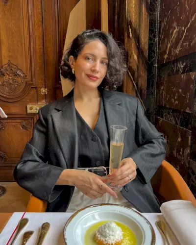 A woman dining at a restaurant with a voluminous bob hairstyle
