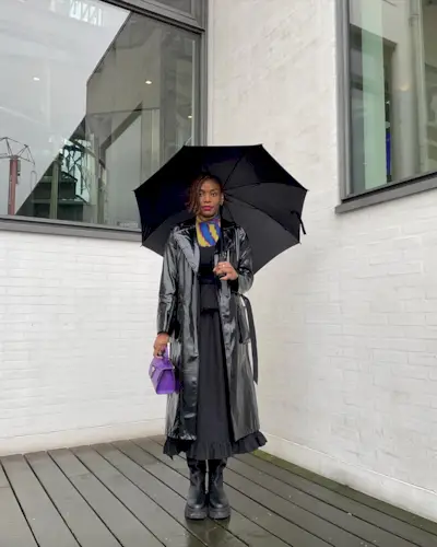 A woman with an asymmetrical bob standing under an umbrella