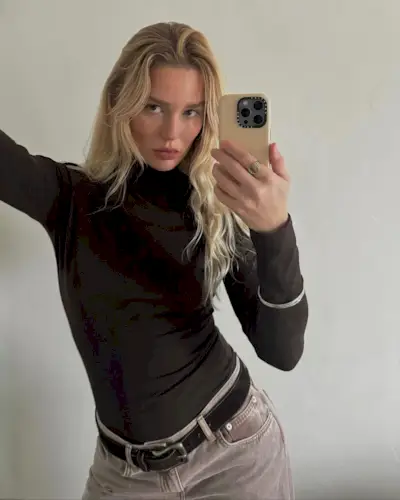 Content creator Megan Adelaide with beachy curls and a chocolate brown turtleneck.