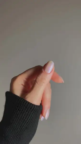 A dual-chrome manicure with a sheer nail polish base and pearly pink and blue pigments