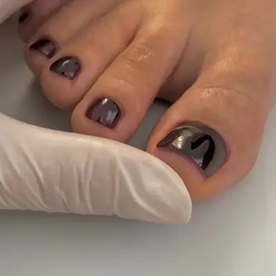 A close-up picture of a burgundy pedicure