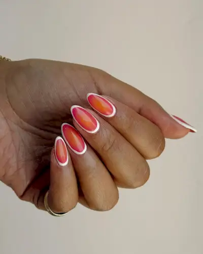 A woman wearing white-rimmed gradient nails.