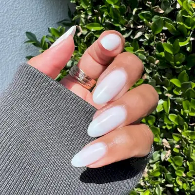 A person wearing a milky white manicure.