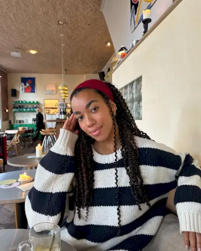 @amaka.hamelijnck wearing a striped jumper and a red headband
