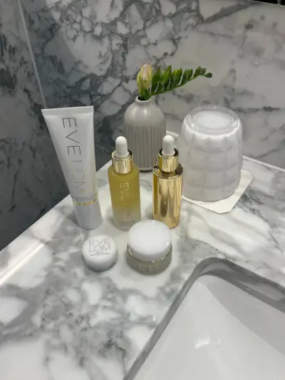Eve Lom beauty products sitting on a marble bathroom counter.