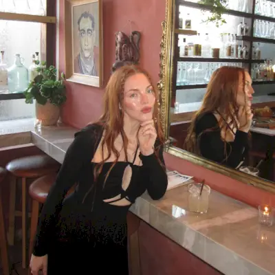 face-framing baby braids on long red hair