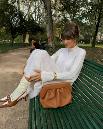 a woman sat on a bench with an updo hairstyle