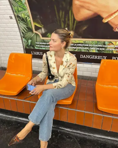 a woman waiting at a station with a slicked-back bun