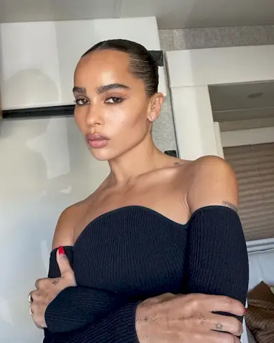 Zoe Kravitz taking a selfie wearing a slicked-back bun.