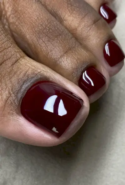 @bombshellnailslondon shows a black cherry pedicure