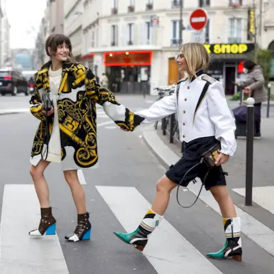 Two women walking on a crosswalk in Paris.