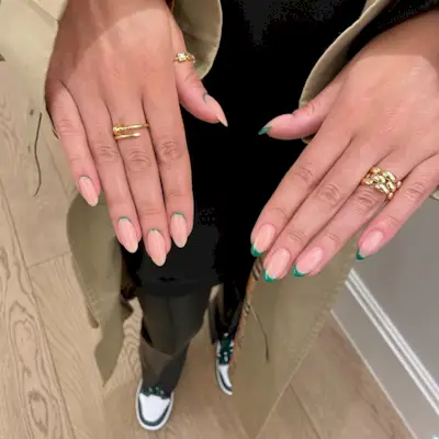 An alternating French tip design, with one hand featuring a classic French tip and one hand featuring a reverse French tip