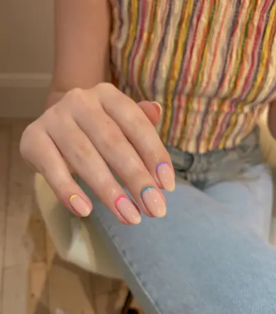 A picture of a rainbow coloured reverse French manicure