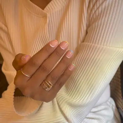 A multicoloured reverse French tip manicure design