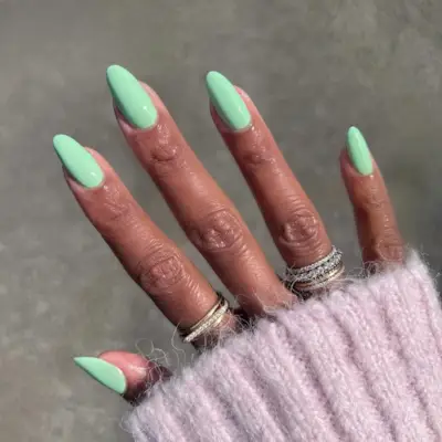 @themaniclub wearing a mint green nail polish and silver and gold rings