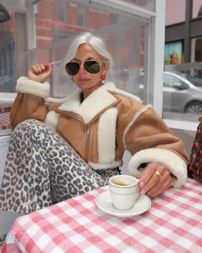 @greceghanem sitting in a cafe with a coffee