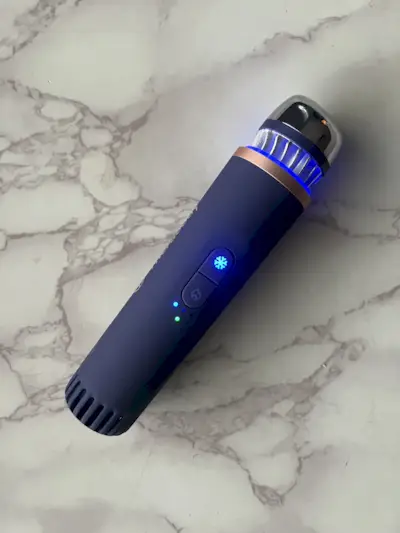 Therabody Theraface Depuffing Wand sitting on a counter.