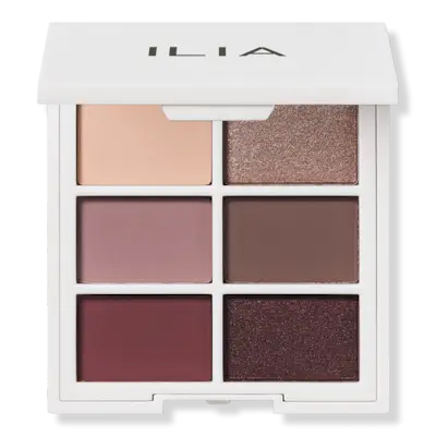 Laura Harrier posing wearing a robe and smoky brown eye makeup.