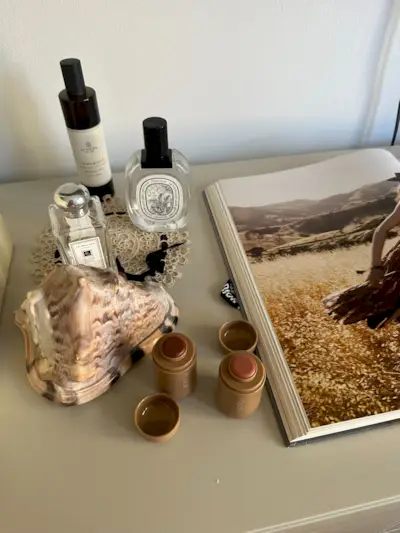 Rhode Pocket Blushes on a dresser with perfumes.