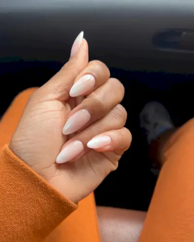 Hand with a milky white manicure.
