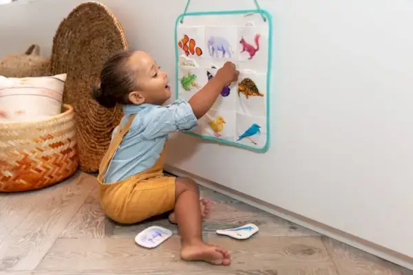 Toddler playing with the Quilted Critter Pockets from The Realist Play Kit