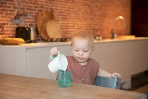 Child pouring water from the Grooved Pitcher & Glass from The Realist Play Kit