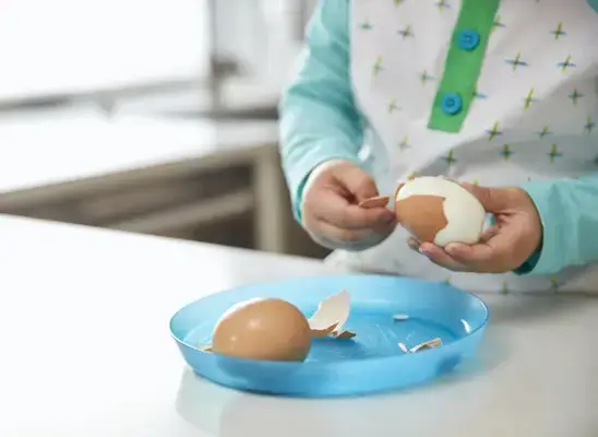 Young child peeling a hard boiled egg